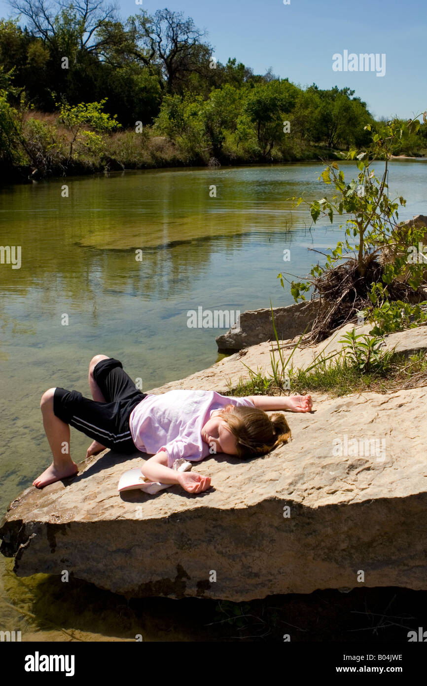 Young girl sunbathes surrounded by the natural Texan landscape. Stock Photo
