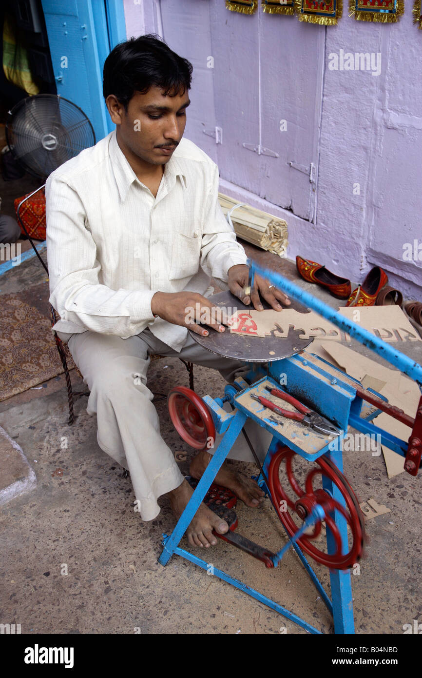 Man using fret saw to create lettering on MDF, Jodhpur, Rajasthan, India Stock Photo