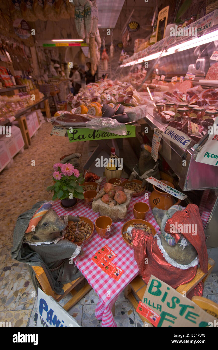 A display of piglets dressed up having a dinner party in a meat shop in the old historic city centre of Florence Stock Photo
