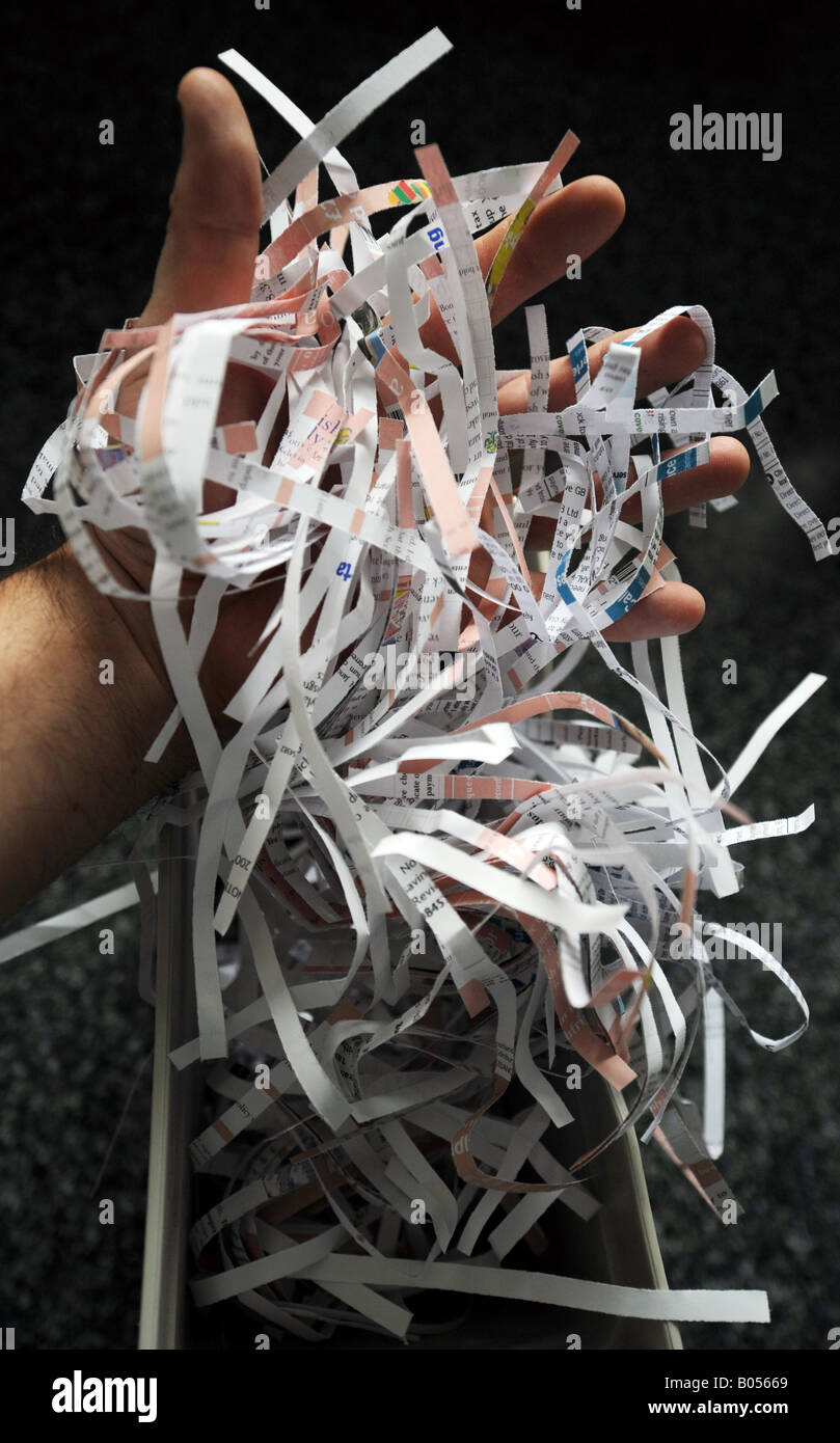 An office worker removes shredded paper from a bin ready for it to be re-cycled Stock Photo
