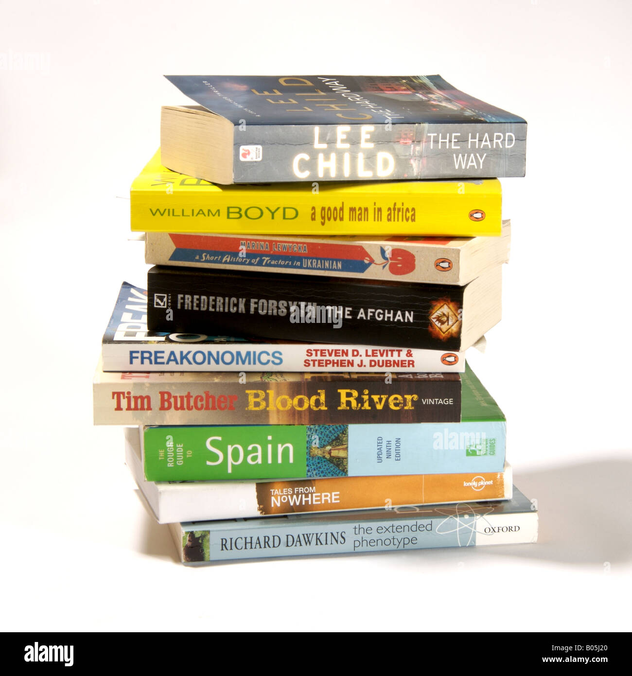 Pile of paperbacks on white background. Stack of bestselling novels, factual, fiction and travel books. Stock Photo