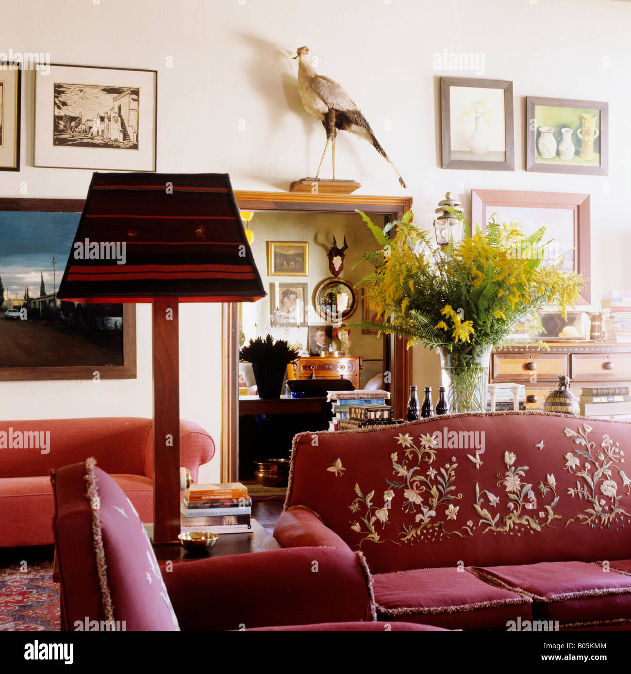 Sitting room with embroidered red sofa and an eclectic range of historic objects Stock Photo