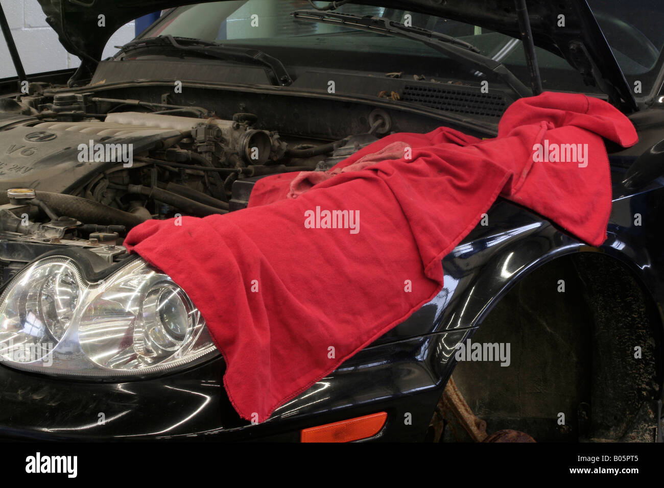 Car under repair with shop rags covering fender Stock Photo Alamy