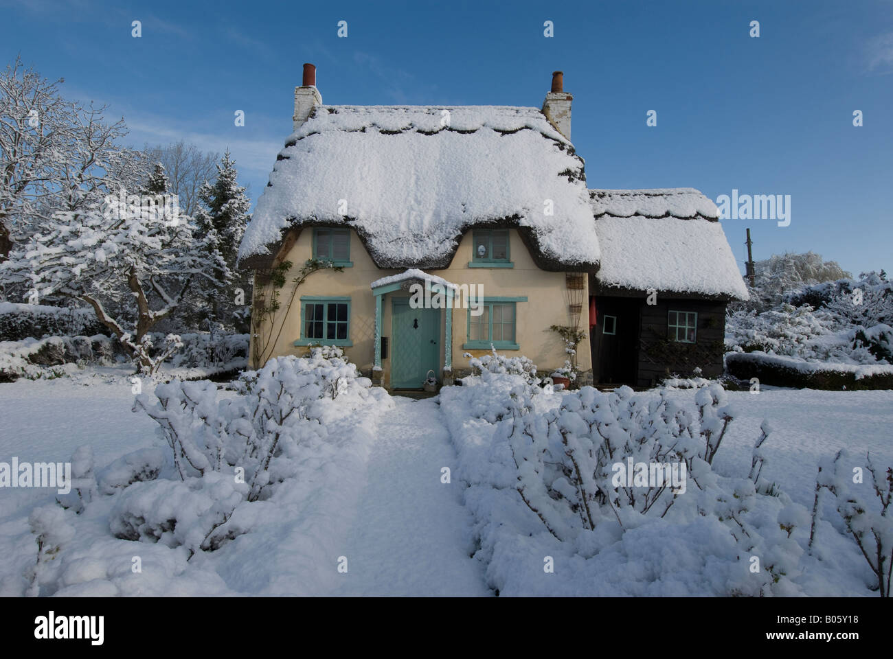 A thatched cottage on a sunny snowy day, Warwickshire, England, UK. Stock Photo