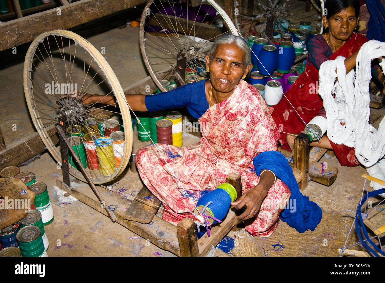 Woman working at Gandhi type spinning wheel in a weaving factory