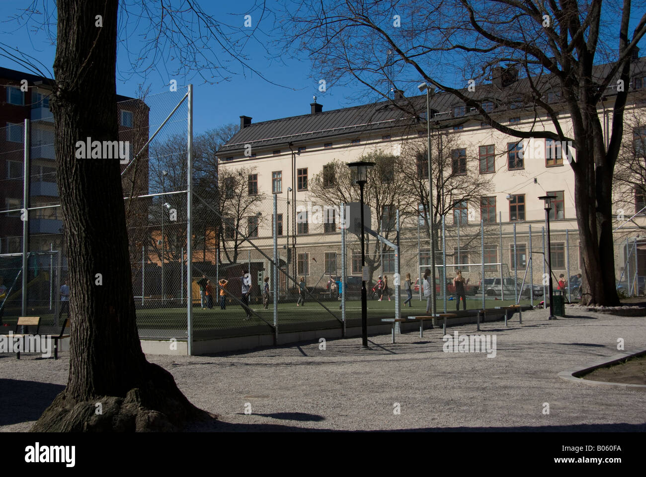 Children playing basket ball on a fenced court in stockholm Stock Photo