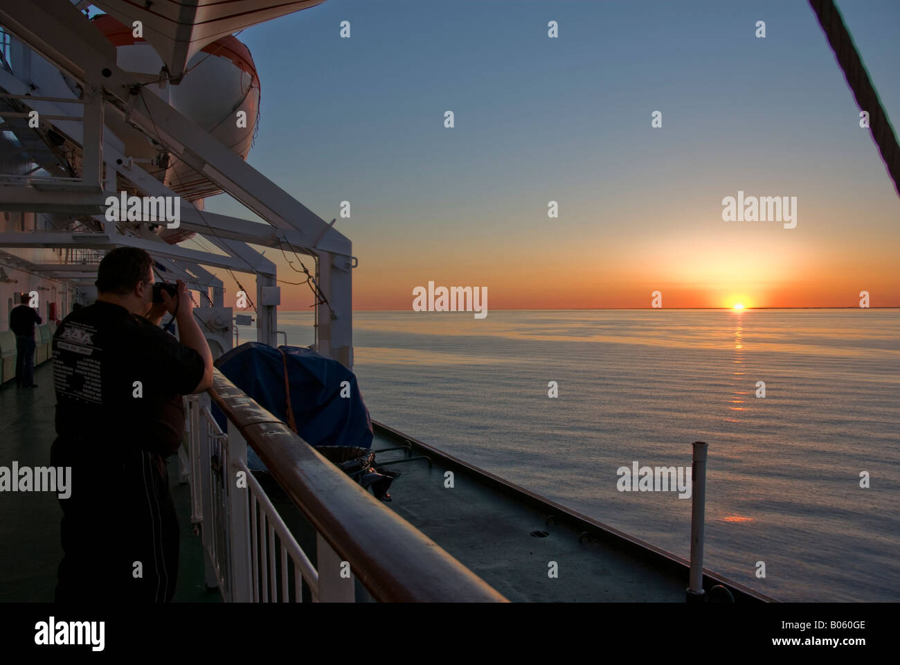 People photographing the sunset on a cruise ship Stock Photo