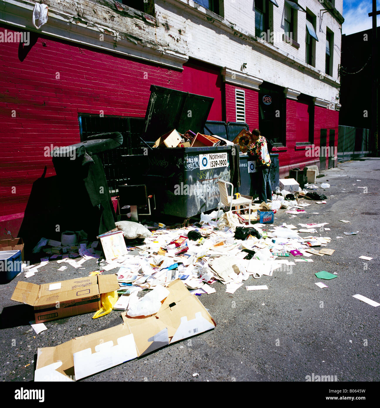 Homeless Man searching through Rubbish in Back Alley Garbage Bins