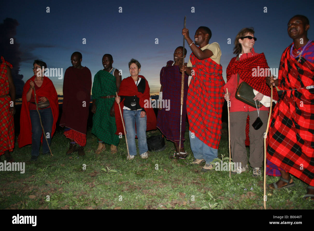 Africa Tanzania Maasai dancing with European tourists in traditional