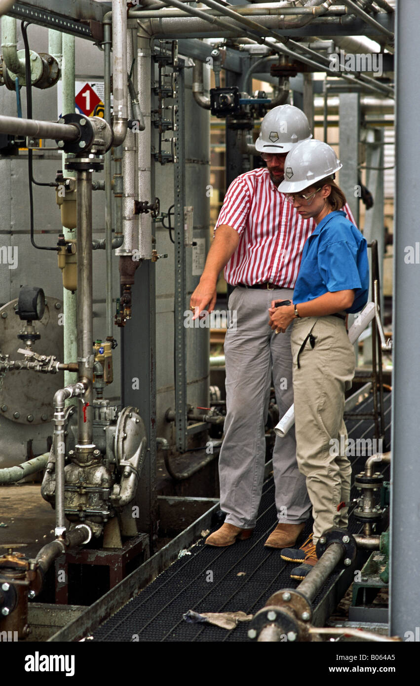 Male and female process engineers wearing appropriate safety equipment ...
