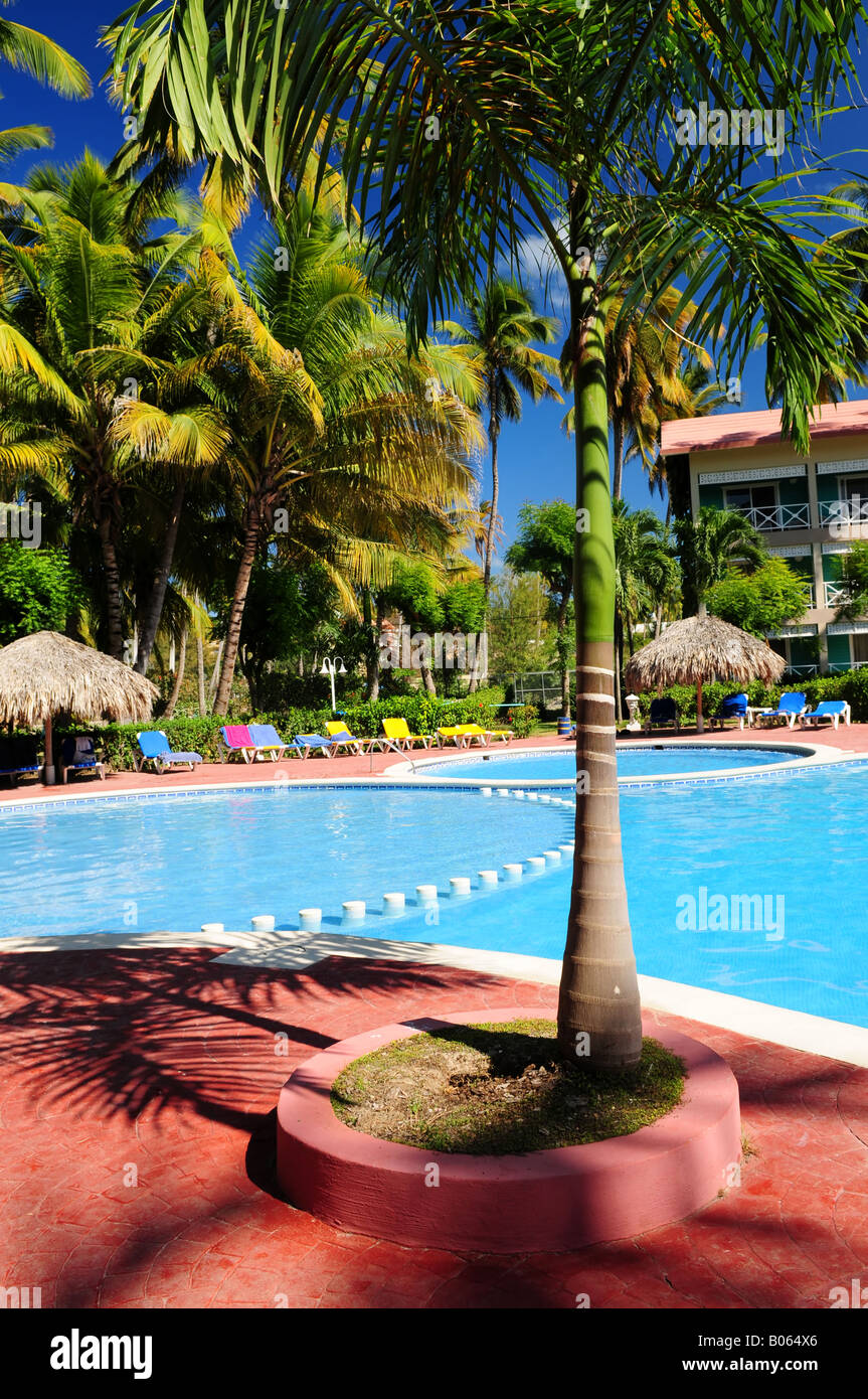 Swimming pool and hotel with palm trees at tropical resort Stock Photo