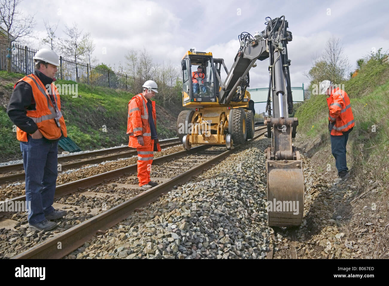 Specialist contractor using road-rail vehicles to excavate and replace outdated track drainage system on a busy rail network. Stock Photo