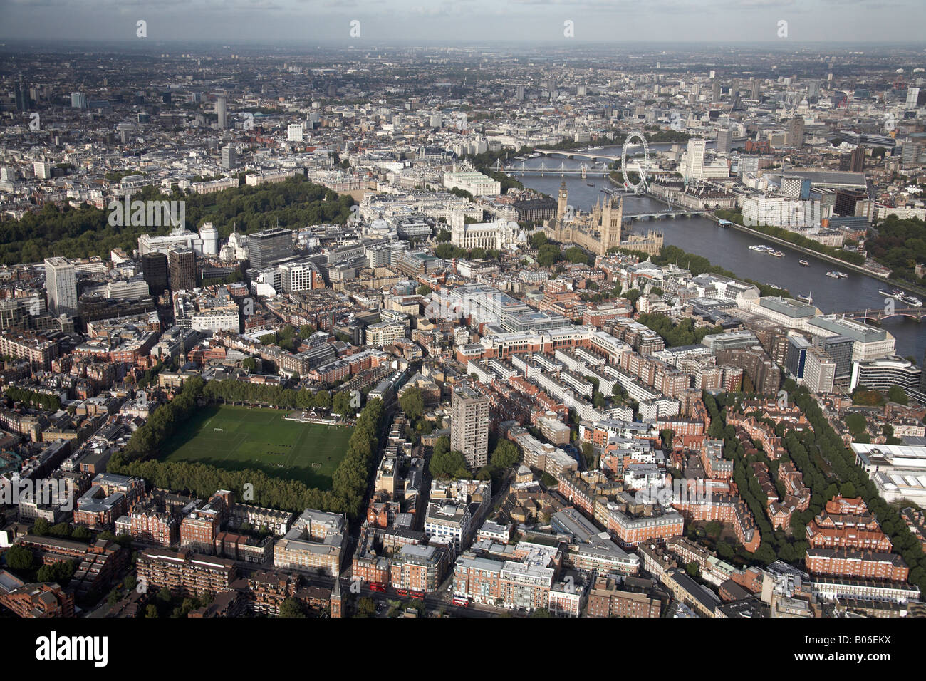 Aerial view north east of inner city buildings Westminster School Playing Fields River Thames Houses of Parliament London SW1 En Stock Photo