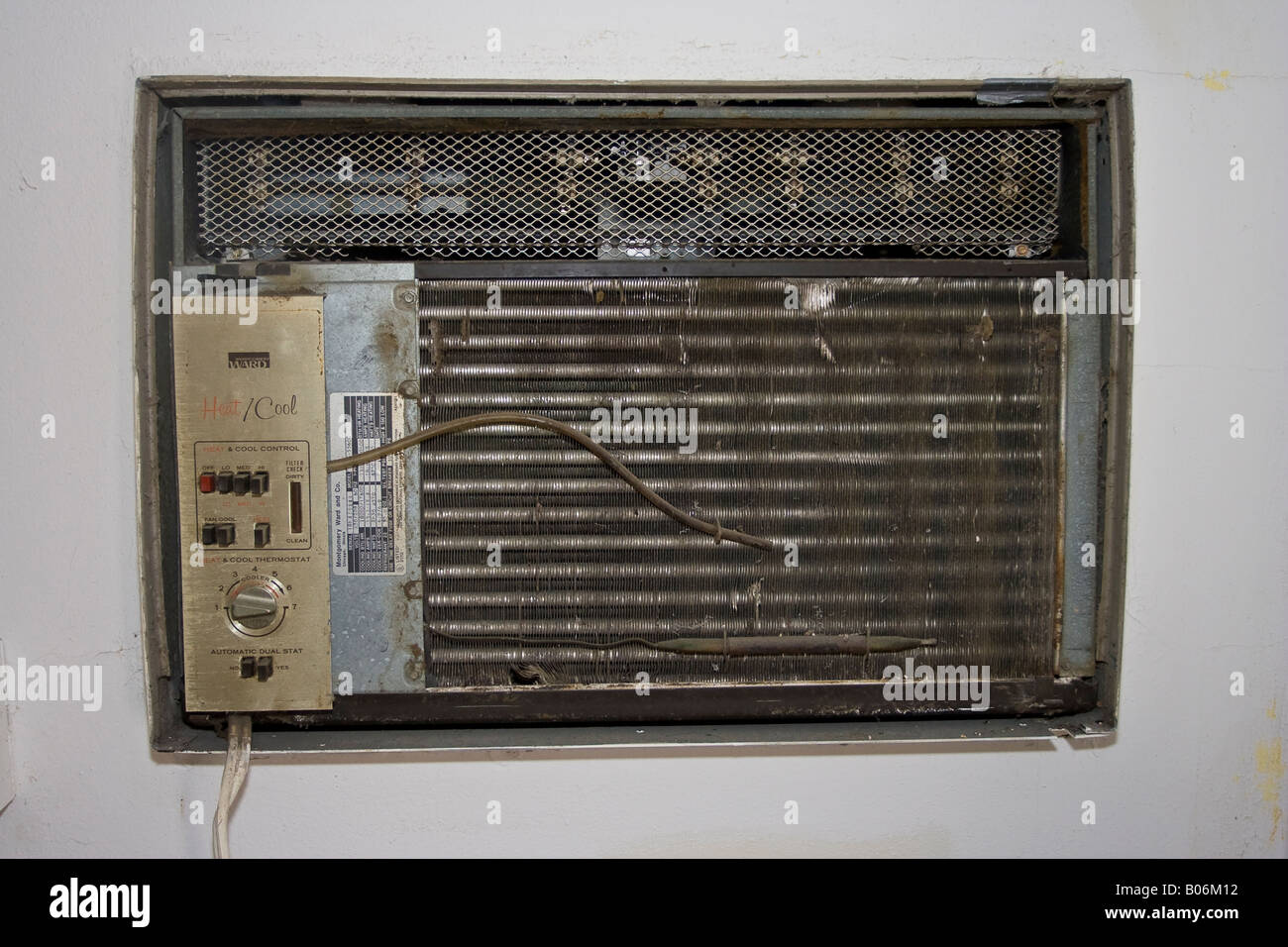 Old Wall Mounted Window Air Conditioning Unit with the Decorative Cover Removed Stock Photo