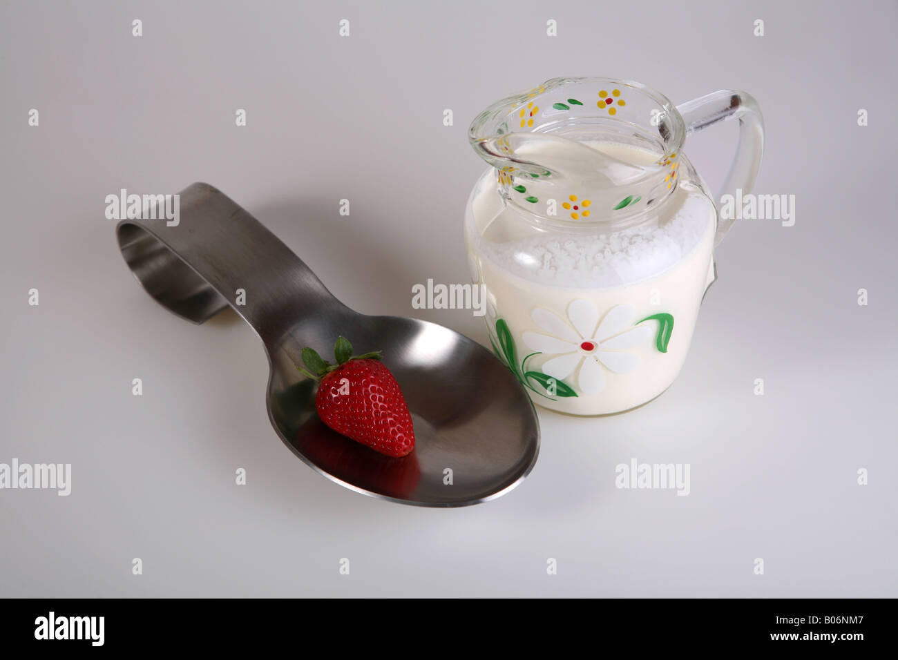 Strawberry in a spoon and cream Stock Photo - Alamy