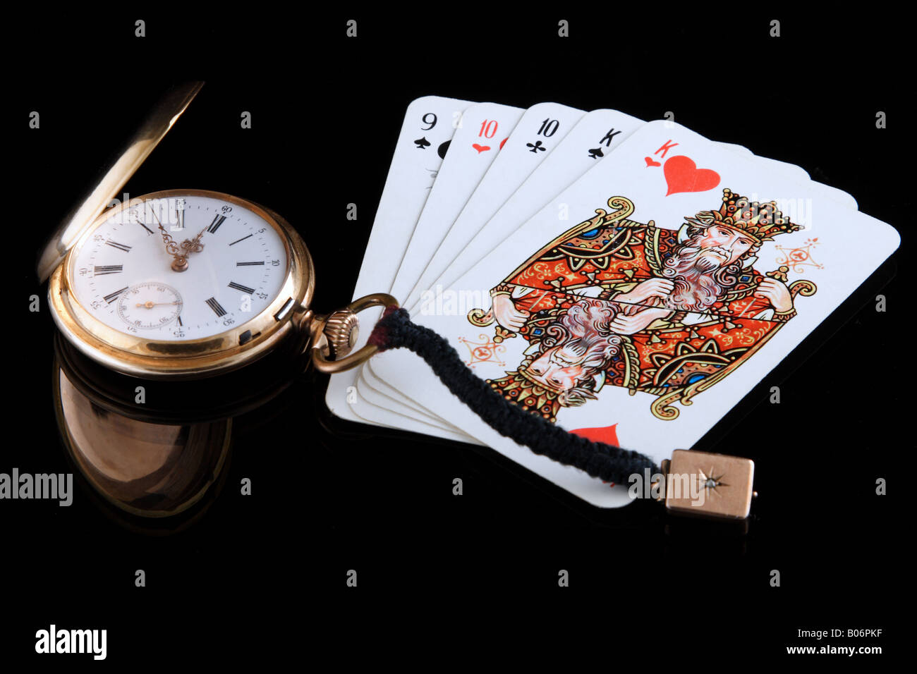 golden watch and playing cards on black background Stock Photo