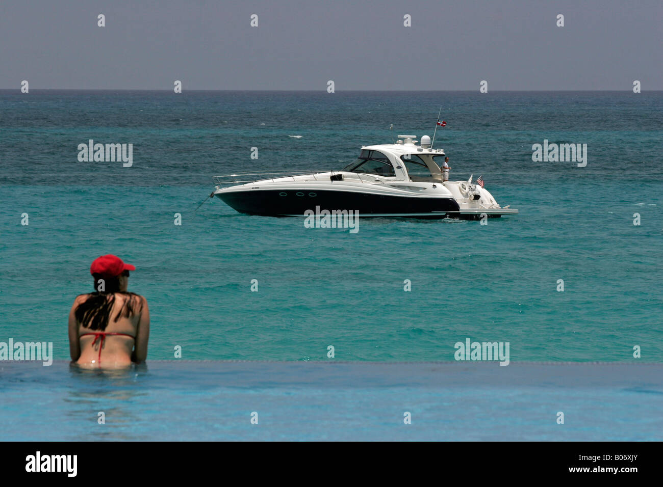 Girl in pool watching boat Stock Photo