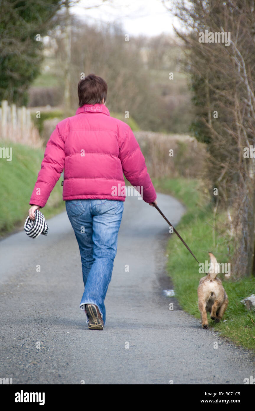 Woman walking down country lane hi-res stock photography and images - Alamy