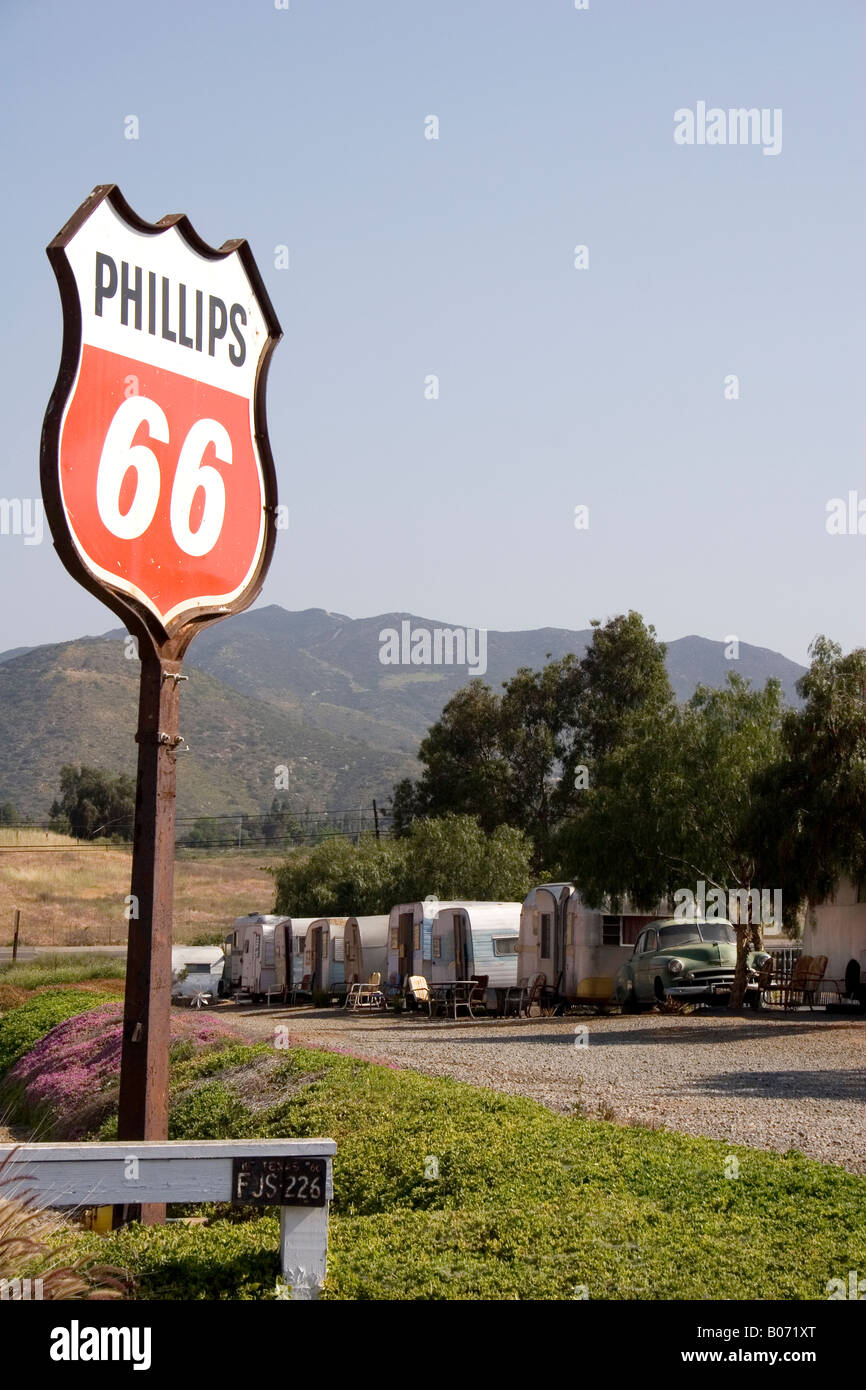 Old travel trailers and gas station sign Stock Photo Alamy
