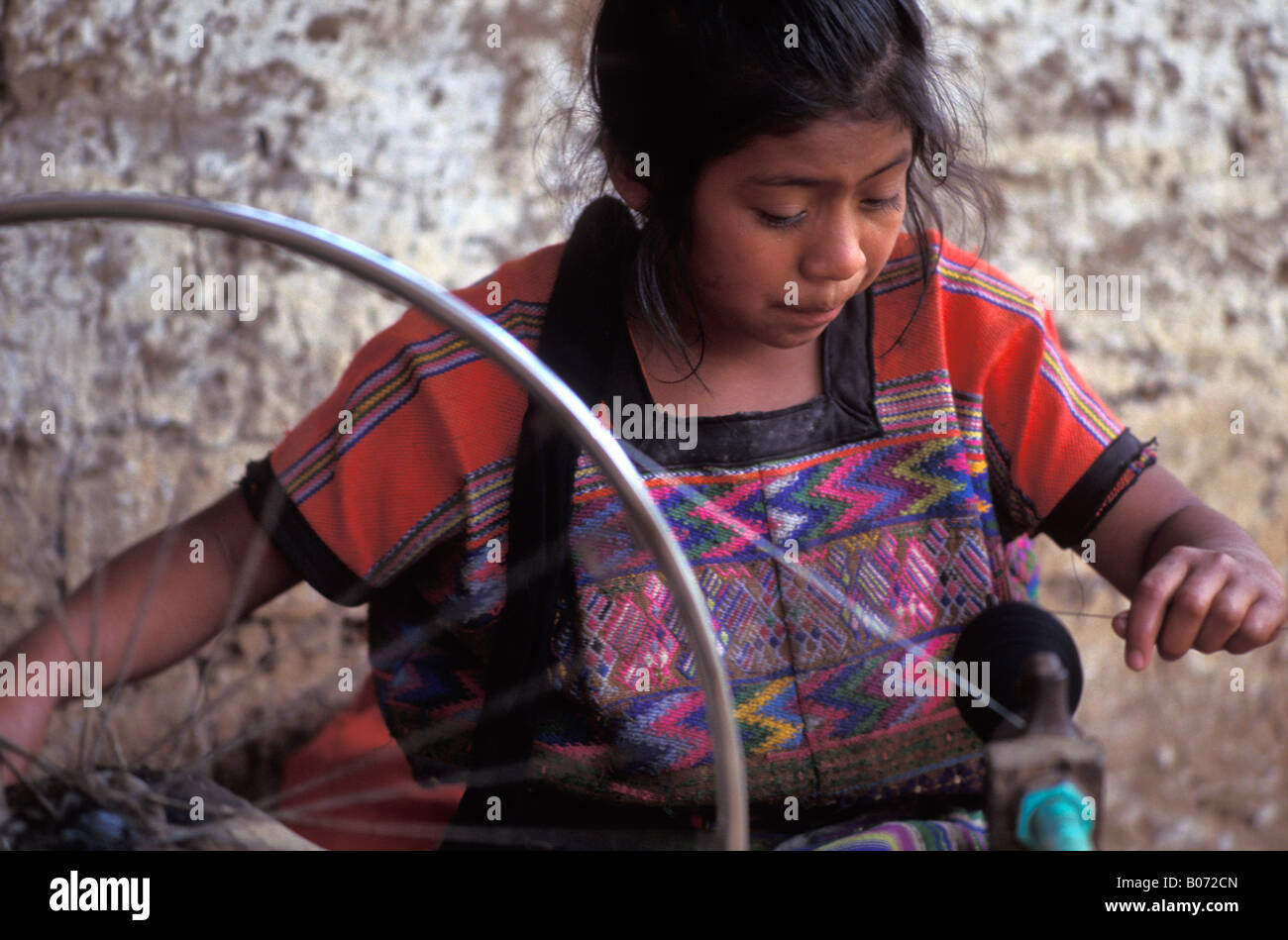 Young Guatemalan mayan girl spinning thread on a bicycle wheel Stock ...