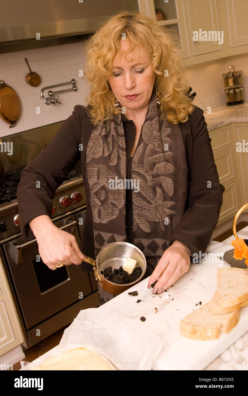 Closeup of Caucasian Woman (40-50) Preparing Black Diamond Truffles Sandwich with Sourdough Bread and Cheese USA Stock Photo