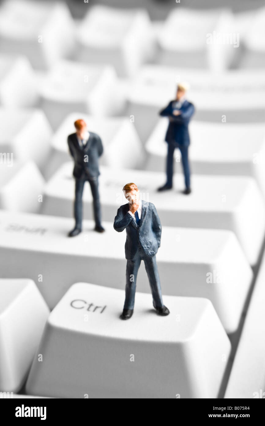 Businessman figurines standing on a computer keyboard Stock Photo