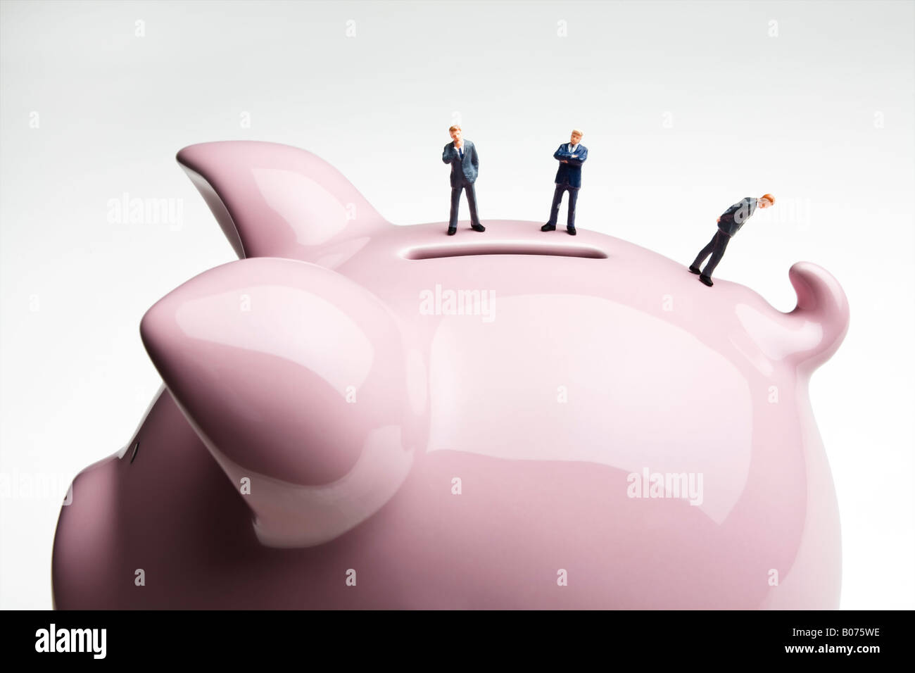 Business figurines standing on a piggy bank Stock Photo - Alamy