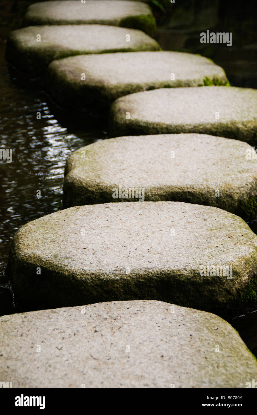 “Stepping stones over a pond in a zen garden in Kyoto Japan Stock Photo
