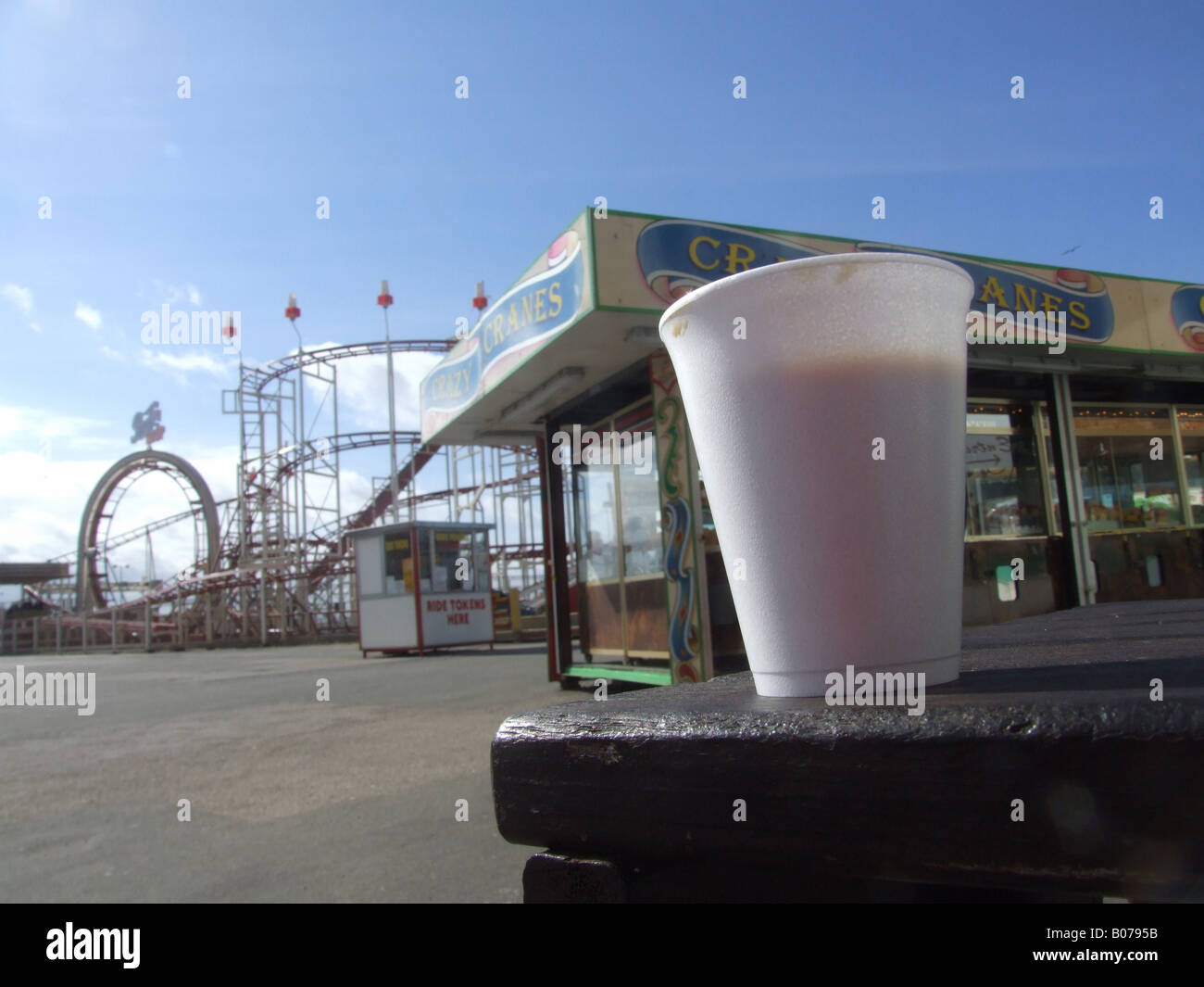 cup of coffee on table at empty  fairground in sun Stock Photo