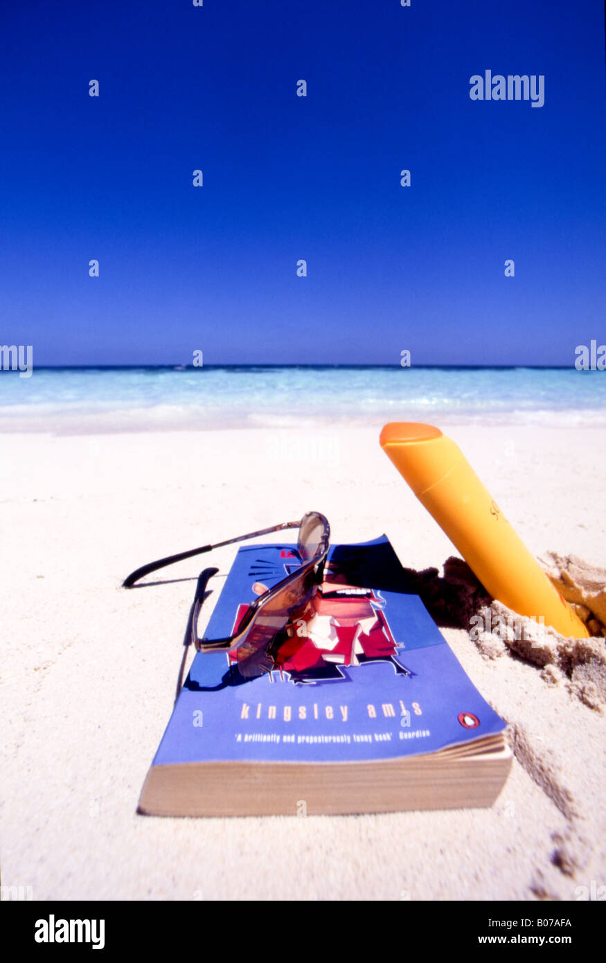 book,glasses and suntan lotion on tropical beach Stock Photo Alamy