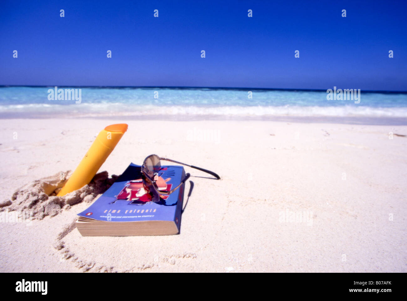 book,glasses and suntan lotion on tropical beach Stock Photo Alamy