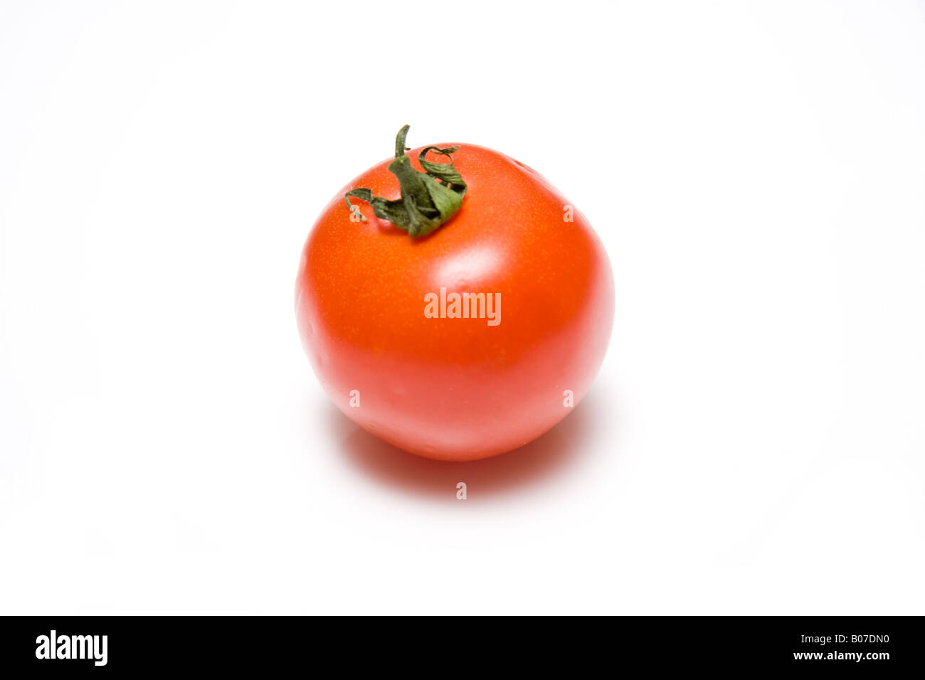 Red tomato isolated on a white studio background. Stock Photo