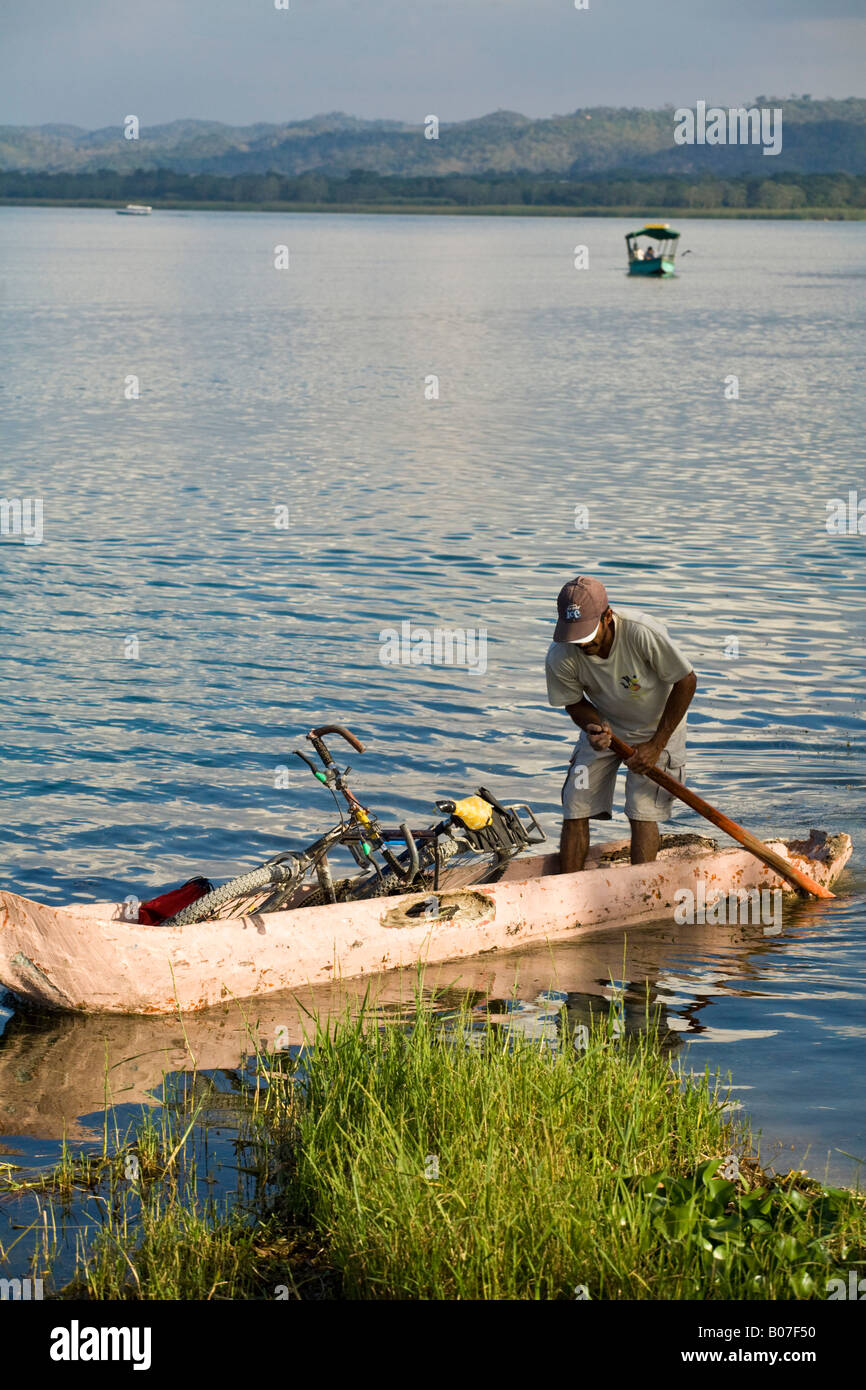 Guatemala, El Peten, Flores, Lago de Peten Itza, Man in dug-out canoe with bike Stock Photo