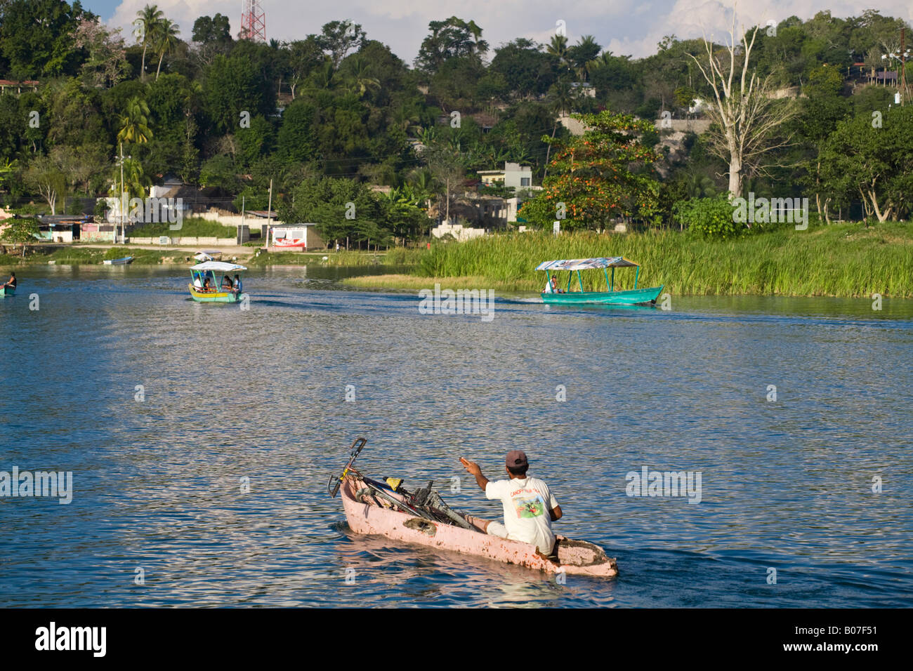 Guatemala, El Peten, Flores, Lago de Peten Itza, Man in dug-out canoe with bike Stock Photo
