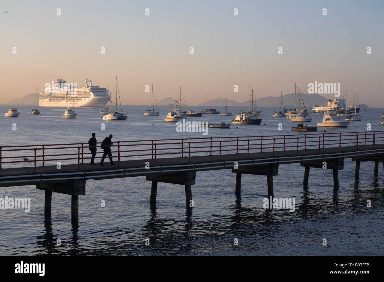 Panama, Panama City, People walking along jetty with a Cruise ship sailing in The Panama Canal Stock Photo
