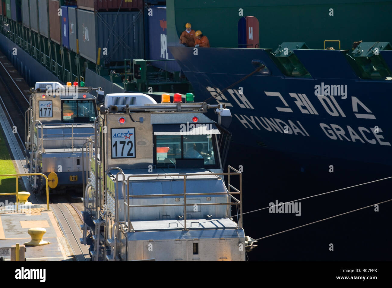 Panama, Panama Canal, Mechanical mule or electric locamotive guiding  container ship through  Gatum locks Stock Photo