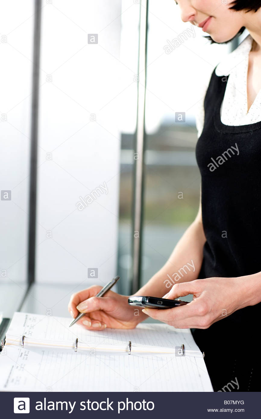 Businesswoman Or Secretary Making An Appointment In A Diary Stock