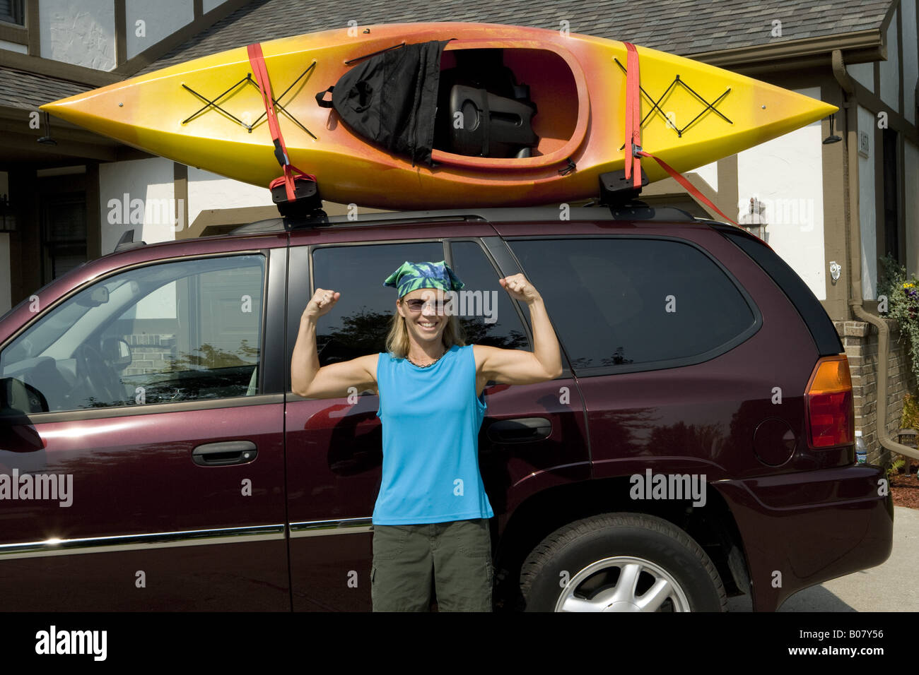 Woman poses next to her SUV with kayak on roof rack Stock Photo Alamy