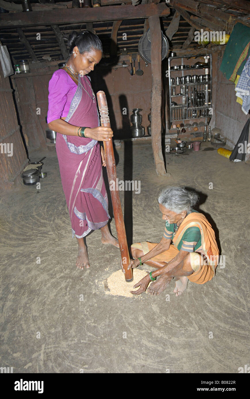 Tribal Womens de-husking rice grains. Warli tribe, Thane, Maharashtra, India Stock Photo