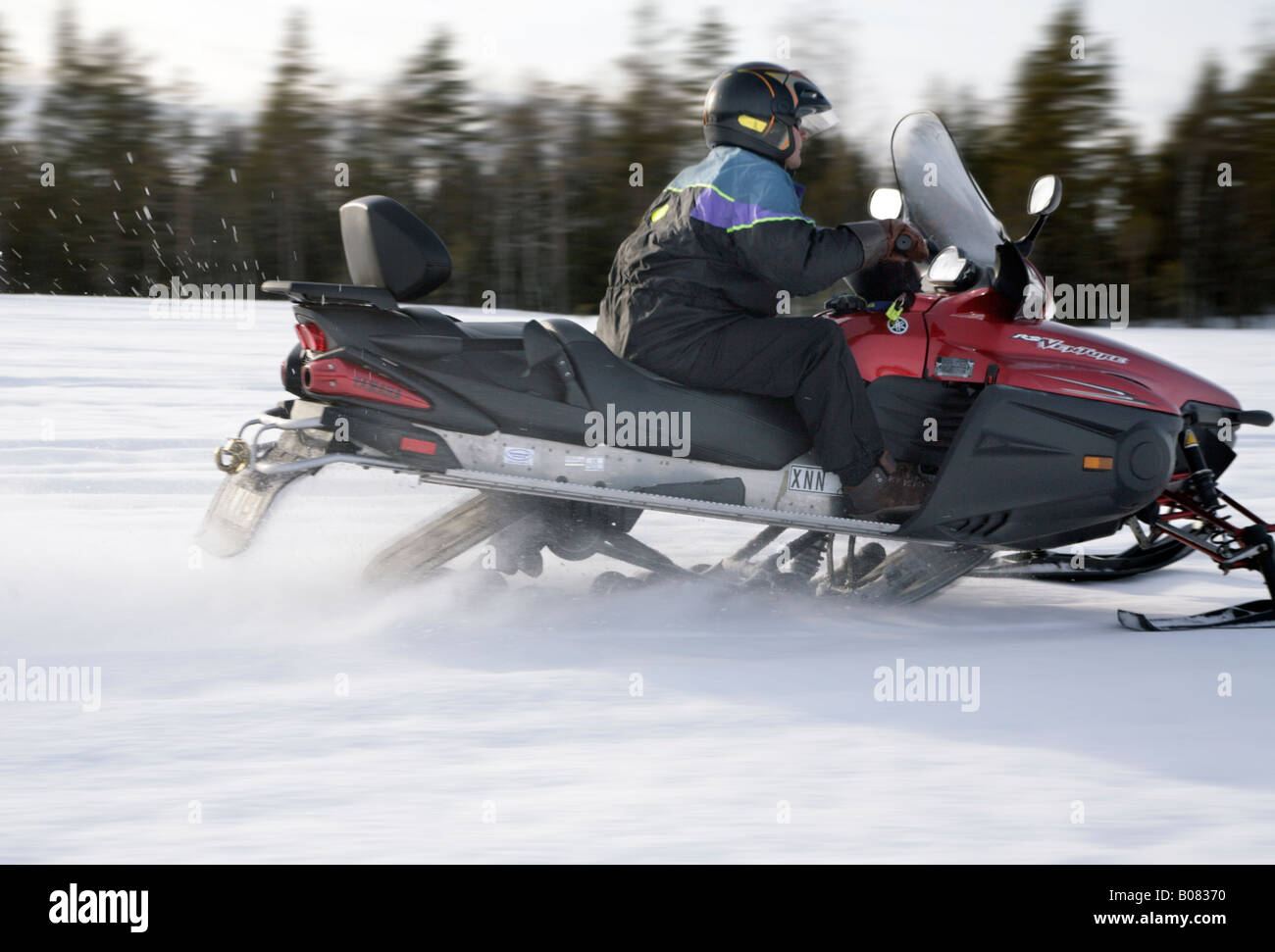 A men in protective sportswear riding snowmobile Branas Ski Resort