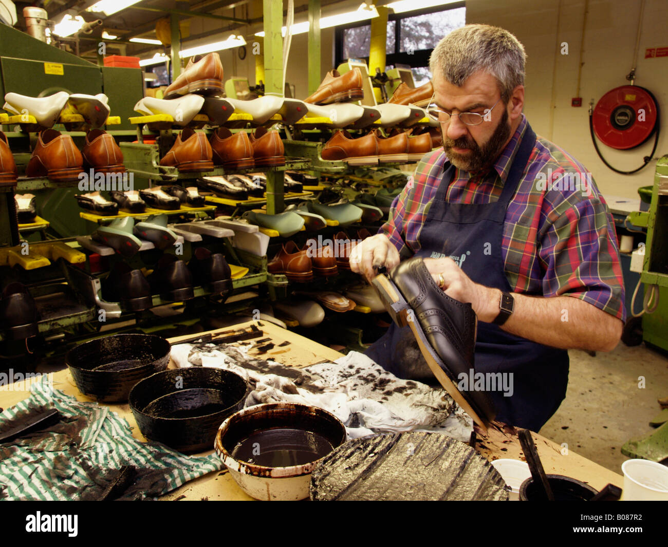 Older gentleman working in a shoe factory doing work manual labour skill craftsmanship van Bommel Stock Photo