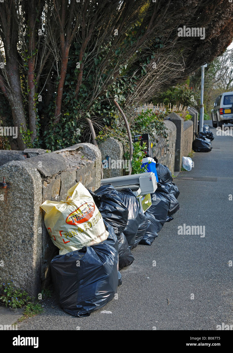 black plastic bags full of refuse, on the pavement ready for collection