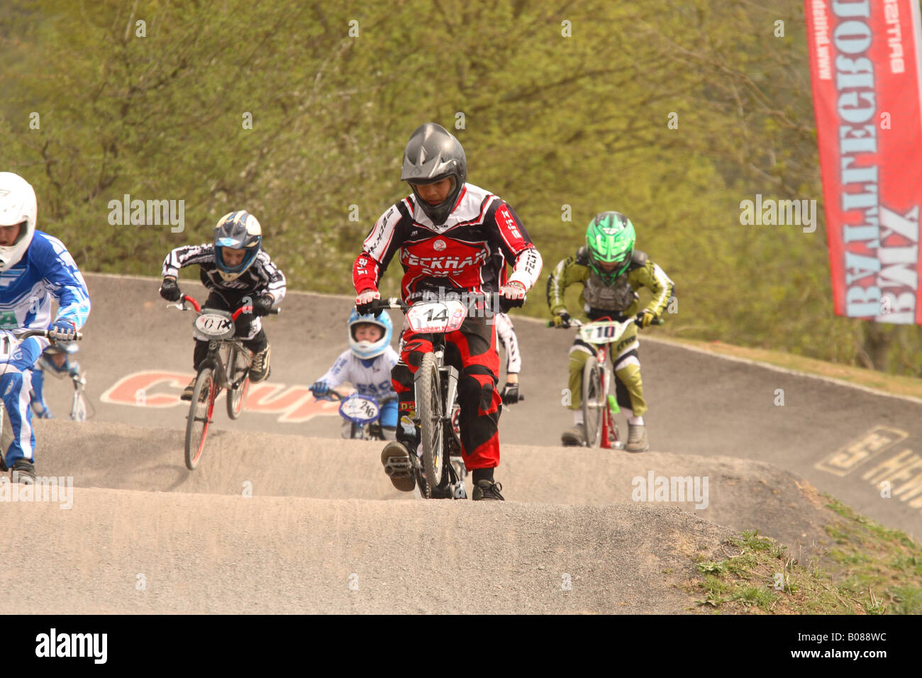 Young BMX bike rider children in national level sport competition jump over a ramp at Cheddar
