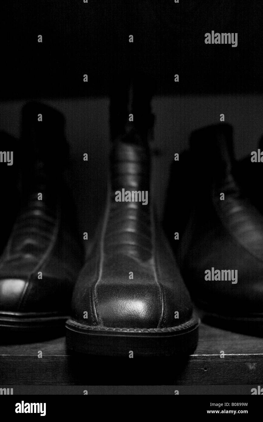 Shiny polished black leather boot shoe on shoe shop shelf Stock Photo