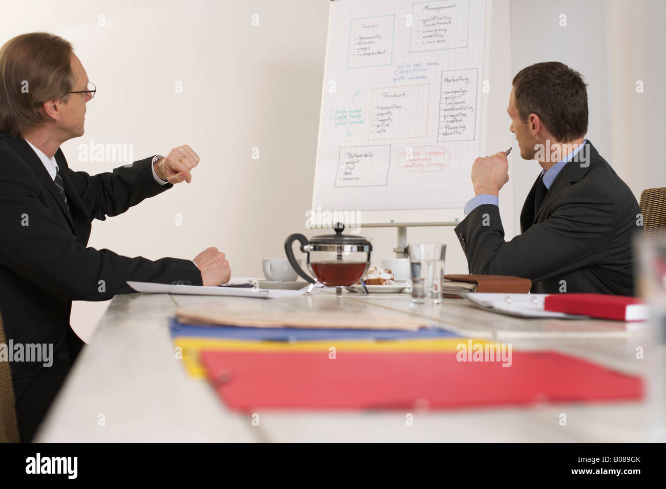 Two men sitting on a bargaining table Stock Photo Alamy