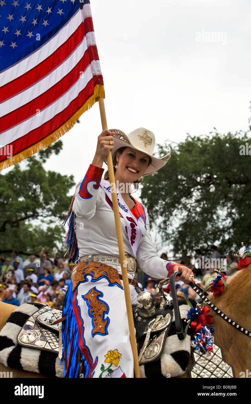 Fiesta Parade Miss Texas Rodeo. Miss Texas Rodeo with USA flag on horse. Stock Photo
