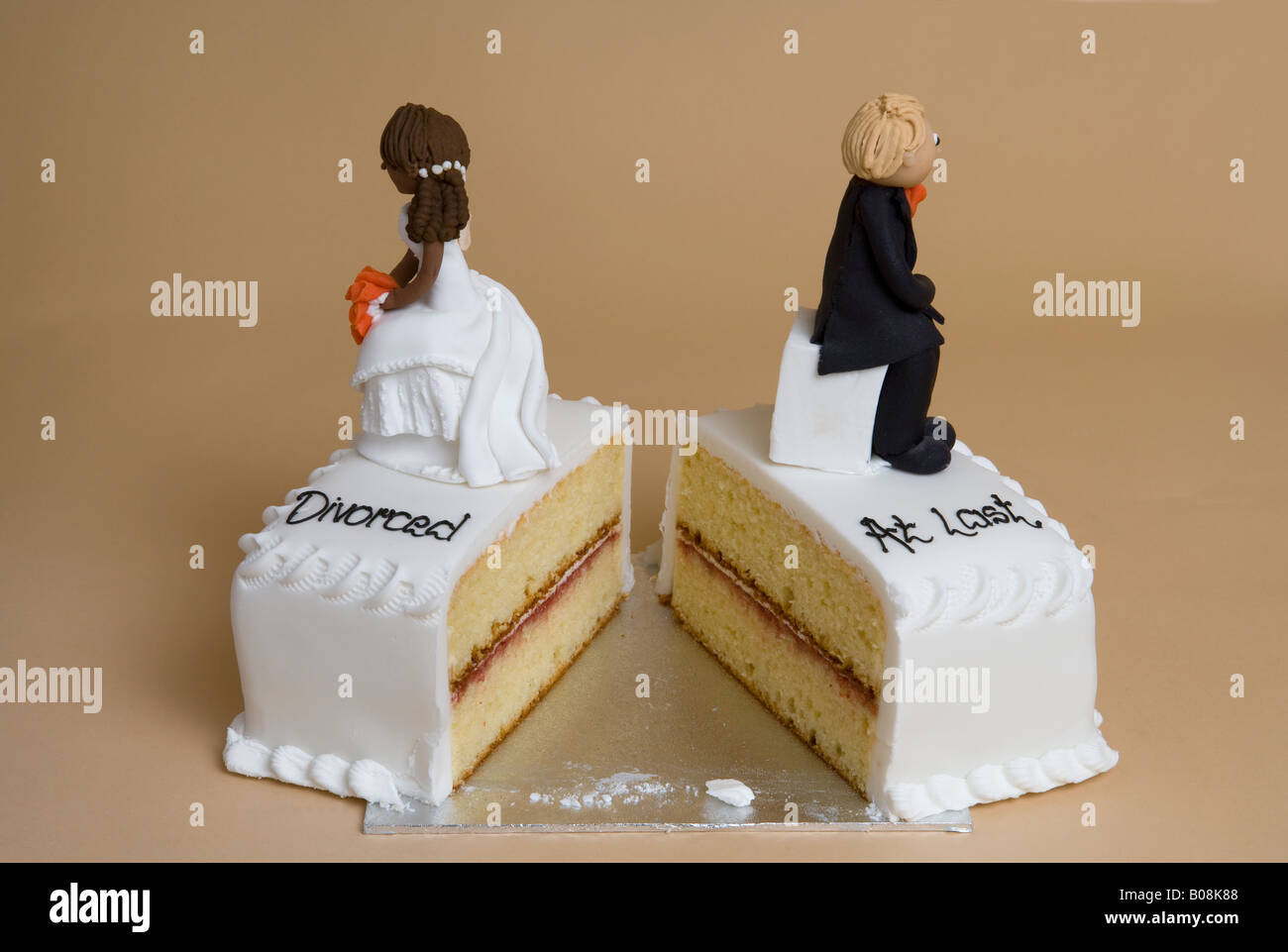Broken wedding Cake with divorced couple back to back Stock Photo