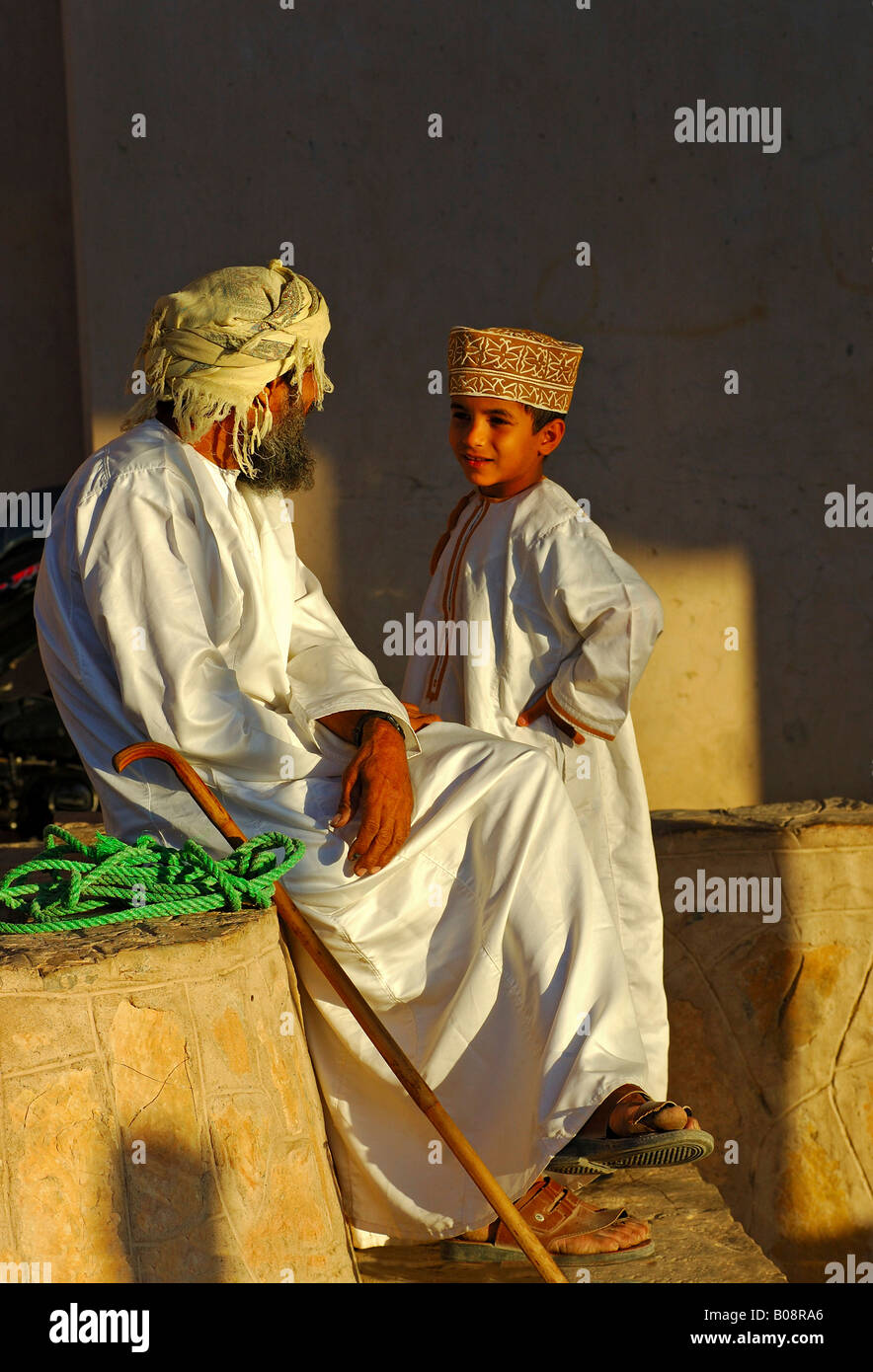 Father and son talking, wearing traditional Omani clothing, Nizwa, Oman, Middle East Stock Photo
