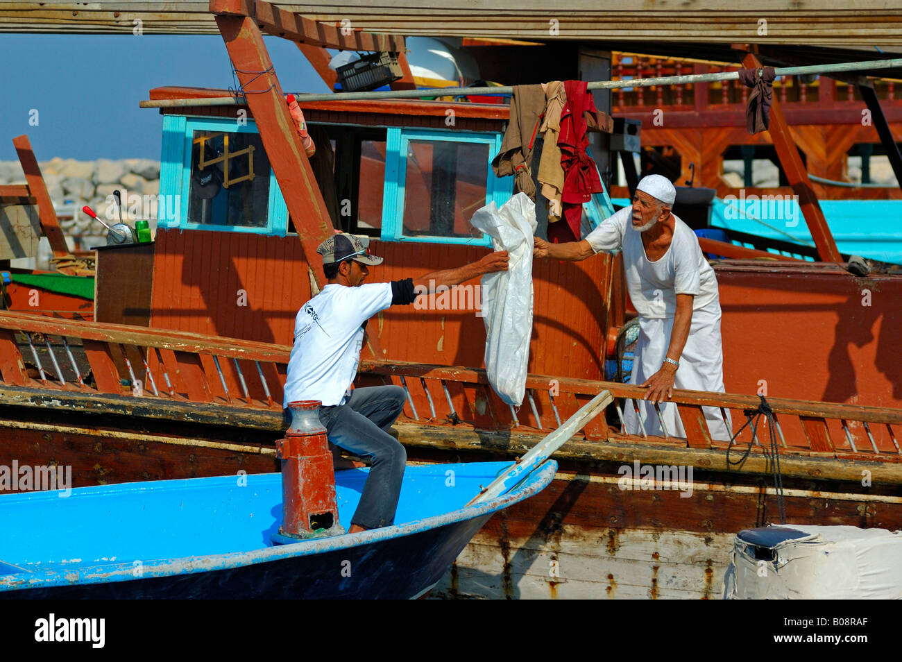 Boatsmen preparing to leave the harbour of Khasab, Musandam, Oman, Middle East Stock Photo