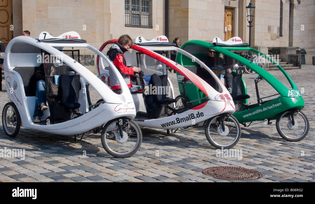Bicycle rickshaw taxis parked on a cobblestone street in Dresden, Saxony, Germany Stock Photo